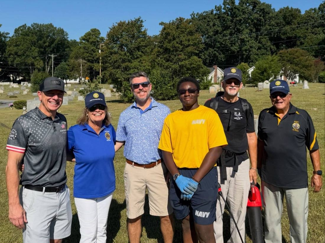 Post 144 officers and volunteers pose together at Greenwood Cemetery after an Operation Respect cleanup day.